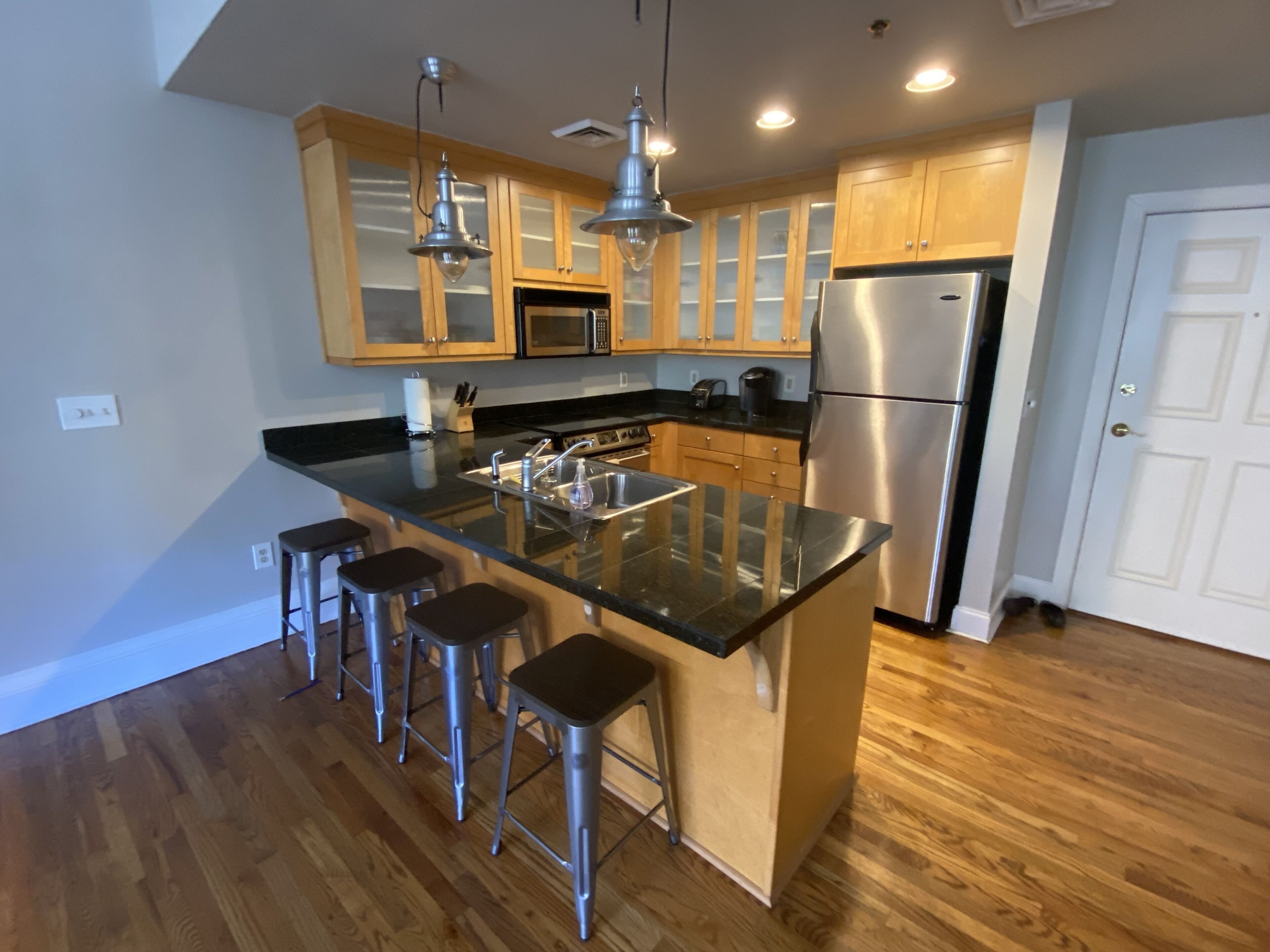 Una cocina moderna con una isla central, electrodomésticos de acero inoxidable y armarios de madera.