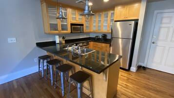 Una cocina moderna con una isla central, electrodomésticos de acero inoxidable y armarios de madera.
