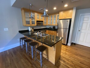Una cocina moderna con una isla central, electrodomésticos de acero inoxidable y armarios de madera.