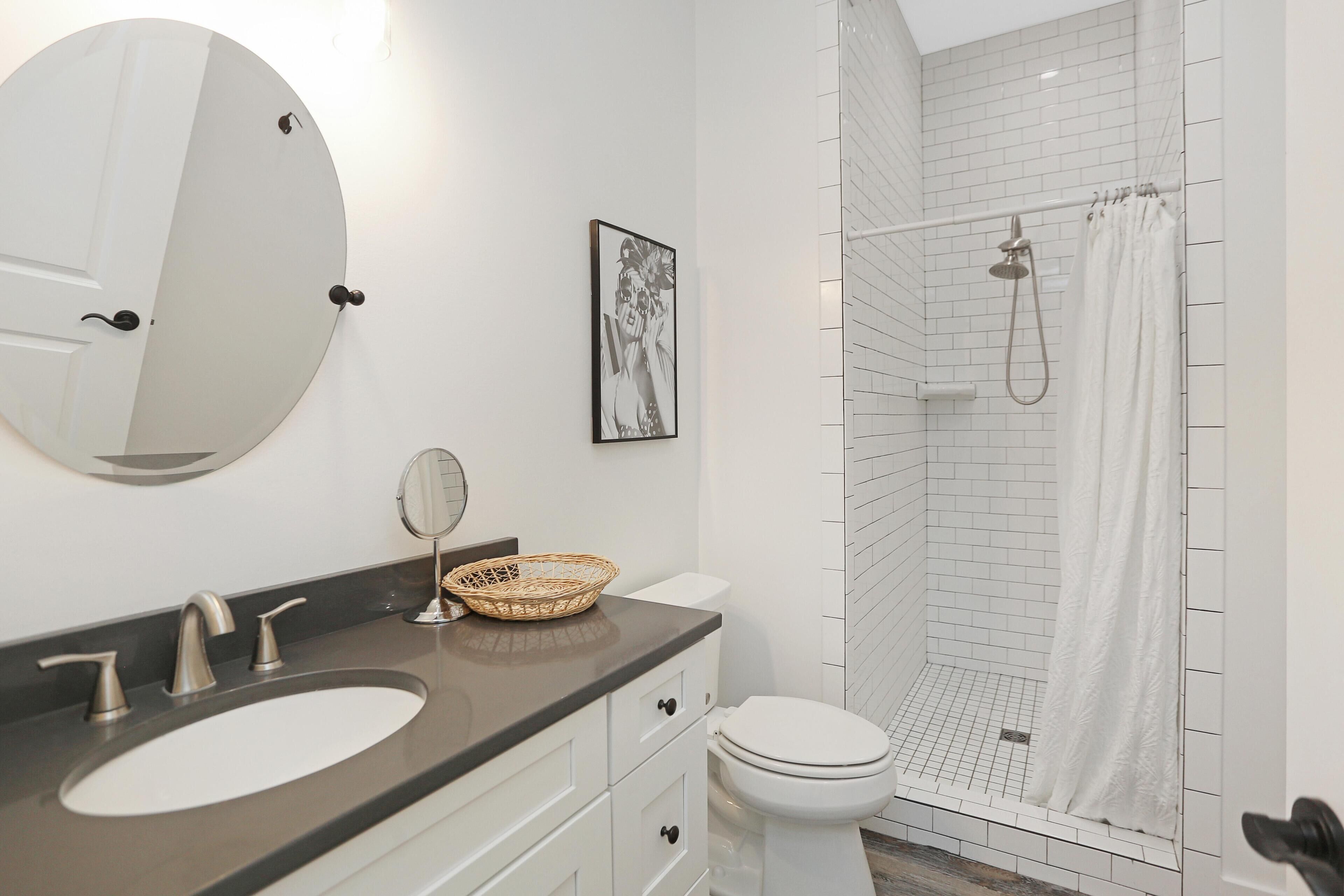 Une salle de bain équipée d’un lavabo, d’un miroir, de toilettes et d’une douche.
