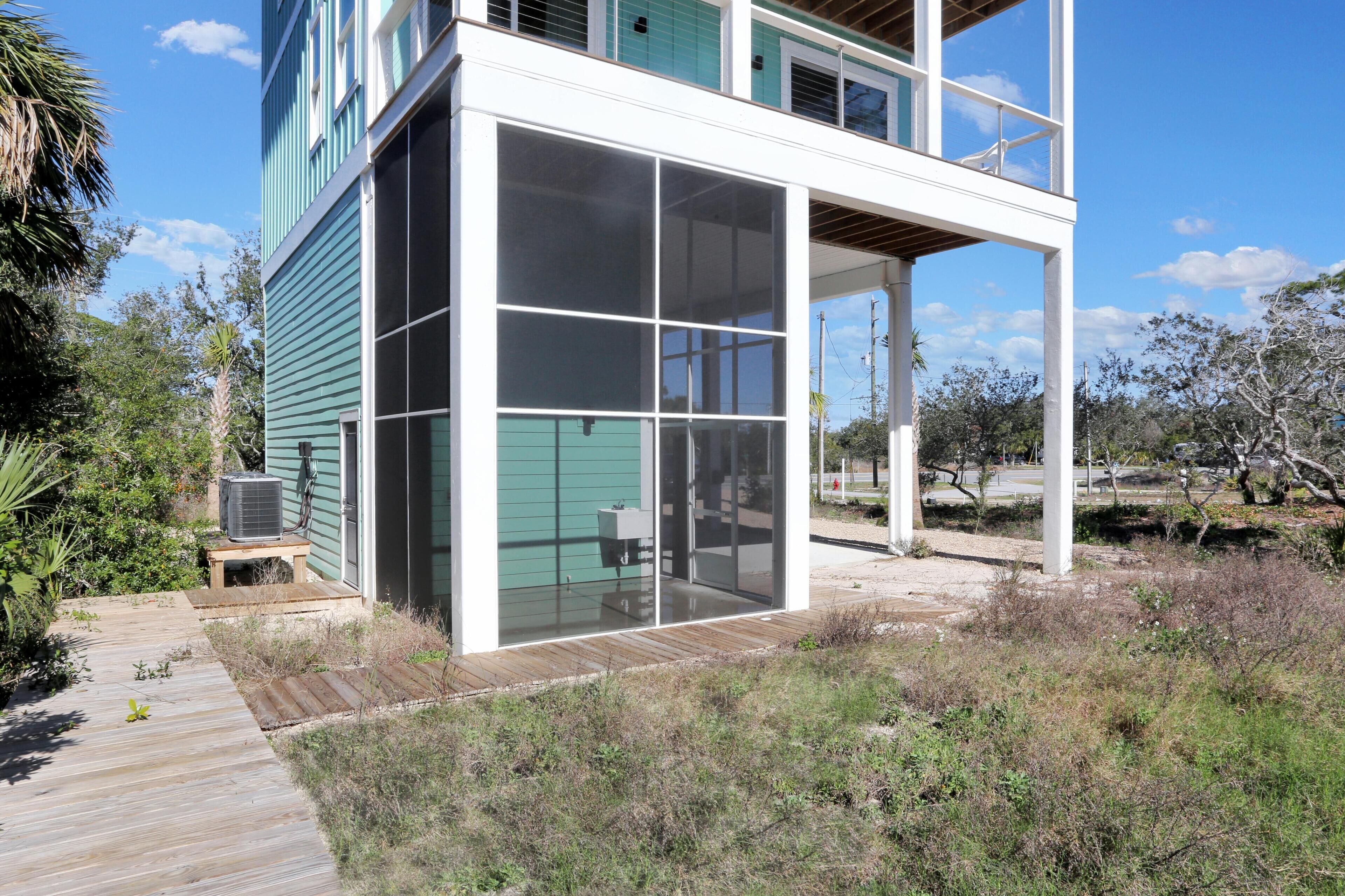 Une maison moderne dotée d’une grande porte vitrée et d’une terrasse en bois.