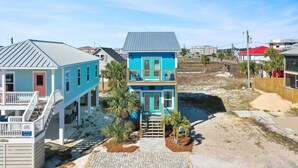 A two-story house with a balcony, a porch, and a driveway. - Hesed Beach Cottage (Port St. Joe)