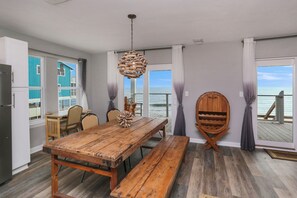Enjoy meals with family and friends at the large dining table, with a view of the ocean from the adjacent balcony.