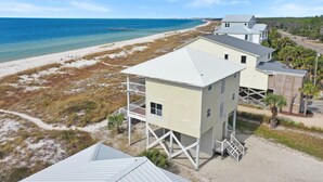 A coastal building with a balcony, a beach view, and a clear sky. - Flamingo Dunes (Port St. Joe)