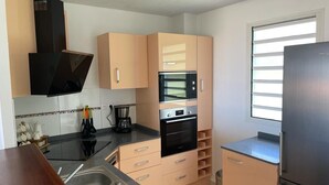 A modern kitchen with a stainless steel sink, double oven, and a built-in microwave. - Beau T3 vue mer Proche Plage Wifi (Trois Ilets)