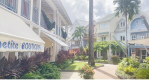 A boutique hotel with a garden courtyard, balconies, and a sign reading "Boutique." - Beau T3 vue mer Proche Plage Wifi (Trois Ilets)