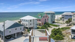 Une propriété située en bord de mer, comprenant plusieurs maisons, un espace de stationnement couvert et une vue sur l’océan.