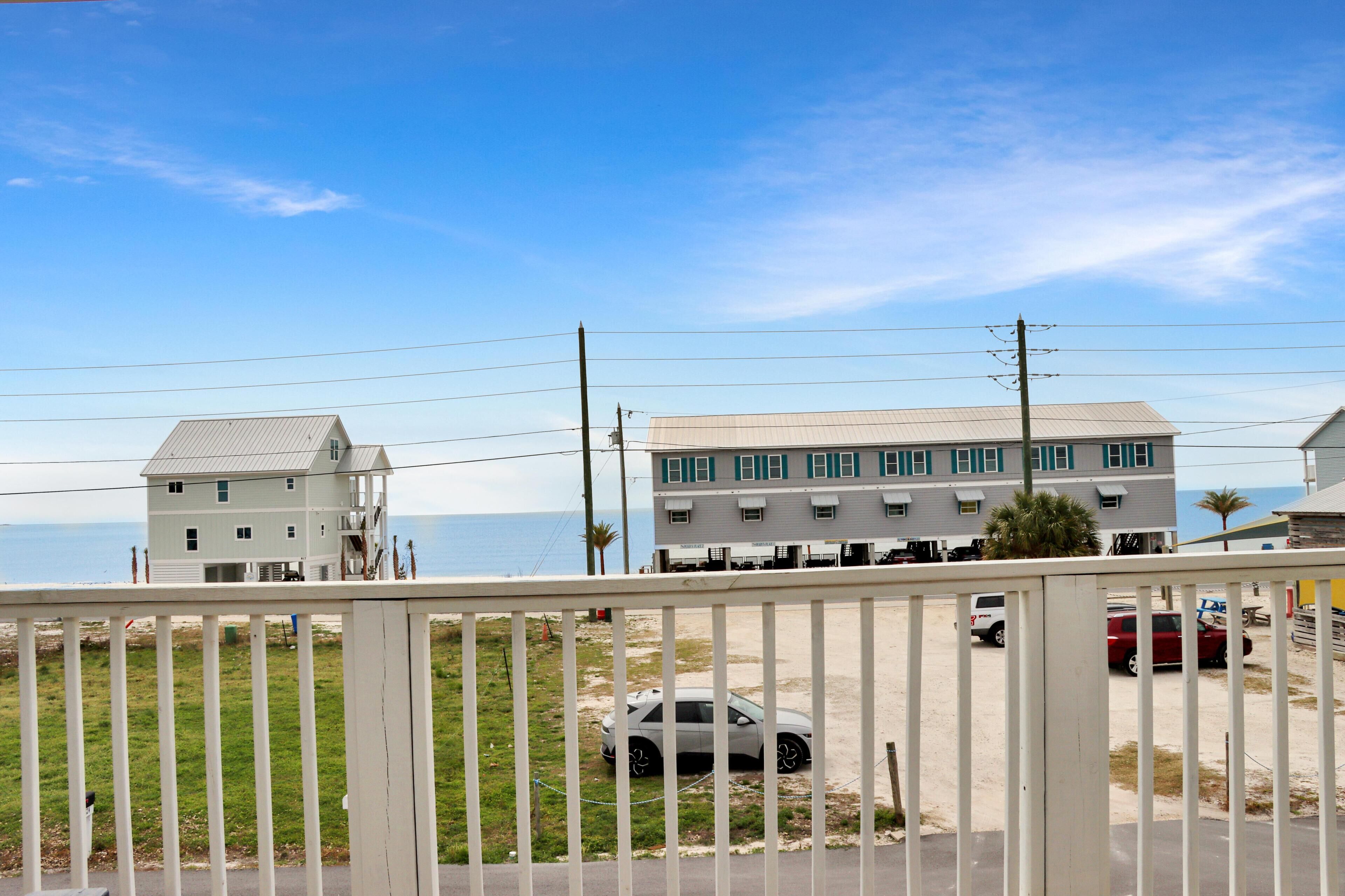 A coastal building with a flat roof, a balcony, and a view of the ocean.