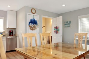A modern kitchen with white cabinets, a dishwasher, and a coffee maker on the countertop.