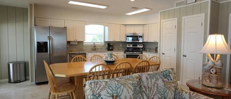 A modern kitchen with a dining area, including a sofa and a lamp.