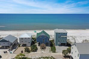 A beachfront property with multiple buildings, a sandy beach, and the ocean in the background. - La Mer (Port St. Joe)