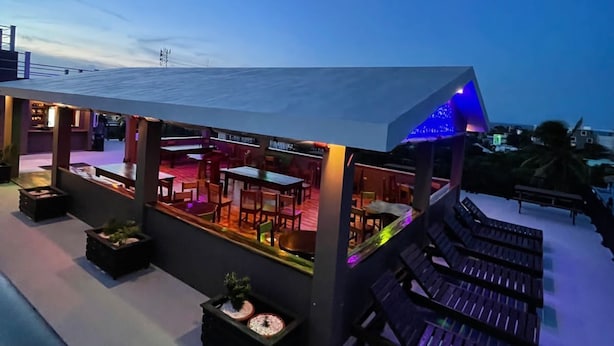 Un espace extérieur aménagé avec des tables et des chaises, une piscine et des chaises longues.