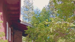 A red building with a staircase leading to a porch. - Cozy Cottage Cabin with Wood Burning Fireplace - Pet Friendly! Charming Updates! (Cloudcroft)
