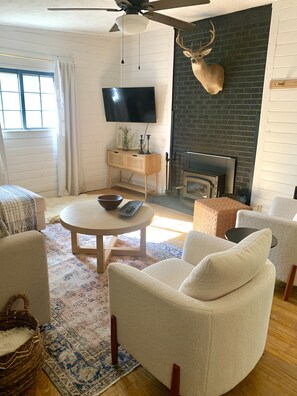 Relax in a warm and inviting space with a cozy seating area, flat-screen TV, and brick fireplace.