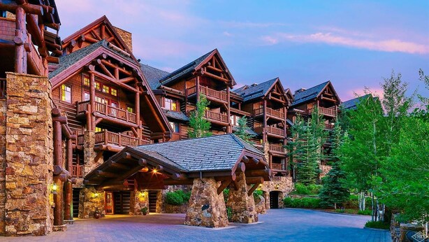 Ein Hotel im Blockhausstil mit mehreren Balkonen und einer Steinfassade.