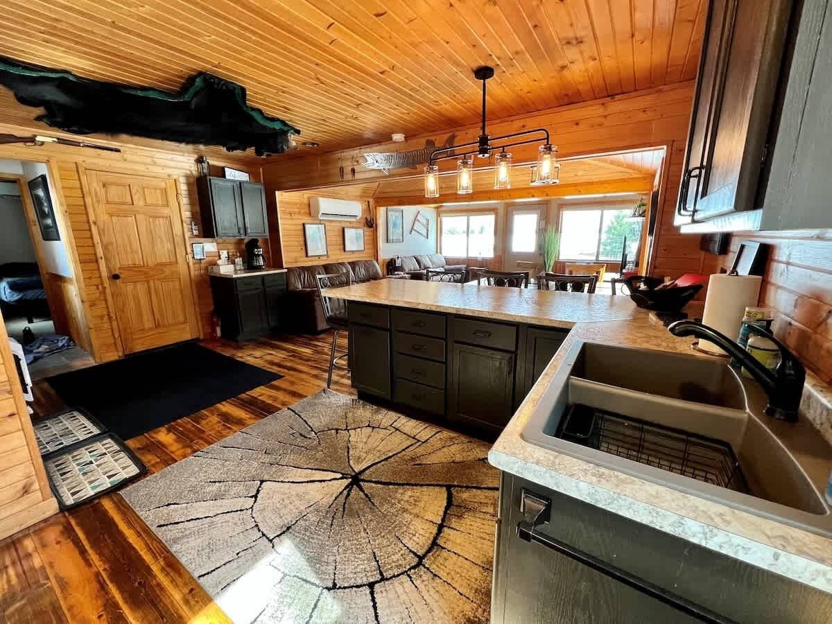 A kitchen with wooden cabinets, a central island, and a large window.