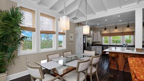 A spacious kitchen with a large island, white cabinetry, and a view of the outdoors. - Sammy's Old Place (Port St. Joe)