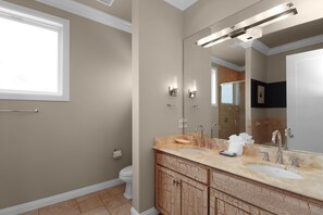 A bathroom with two sinks, a large mirror, and a towel rack.