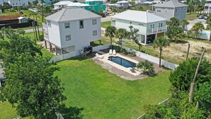 A residential area with houses, a swimming pool, and a fenced yard. - Pearly Shells (Port St. Joe)