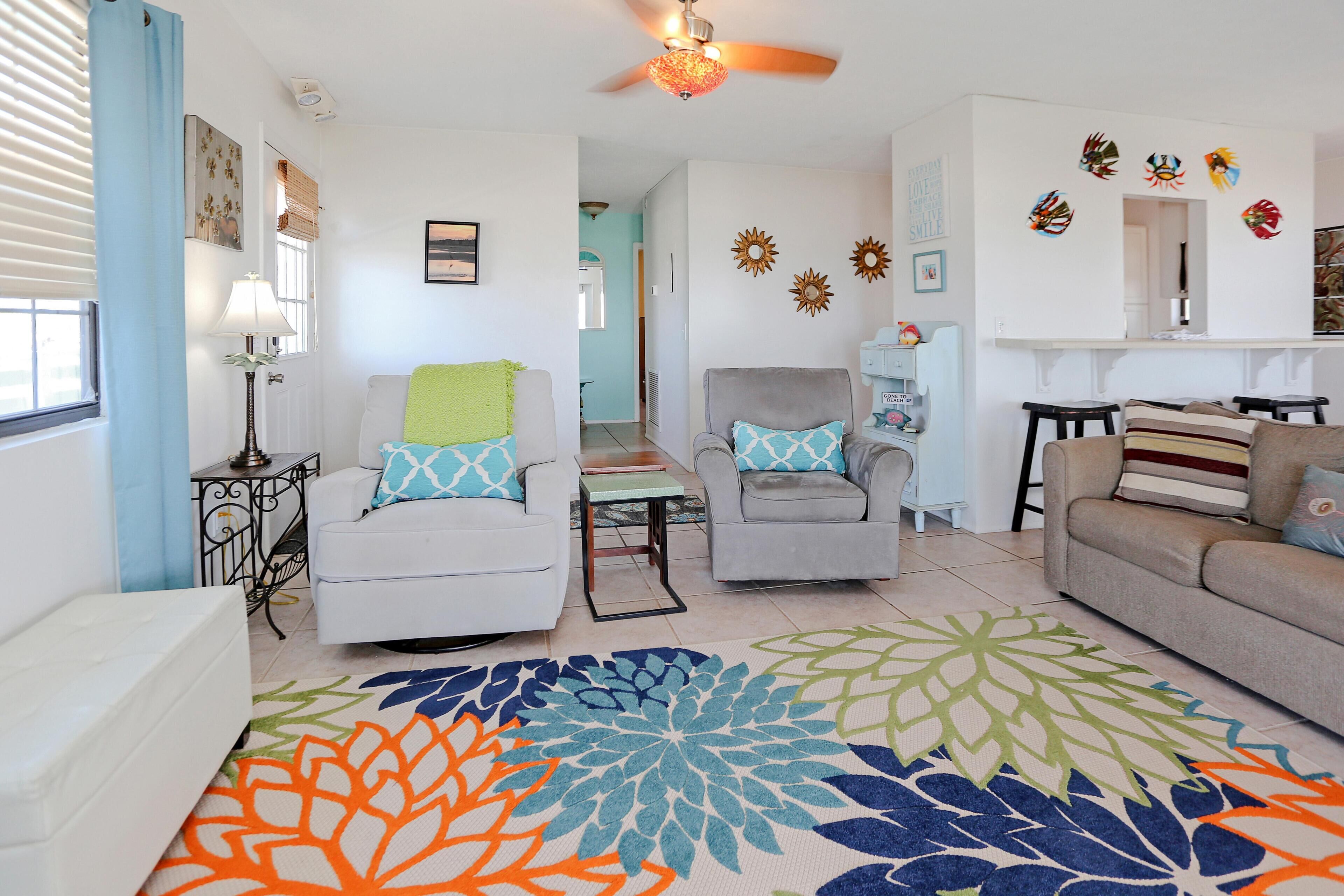 A living room with two sofas, a coffee table, and a patterned rug.