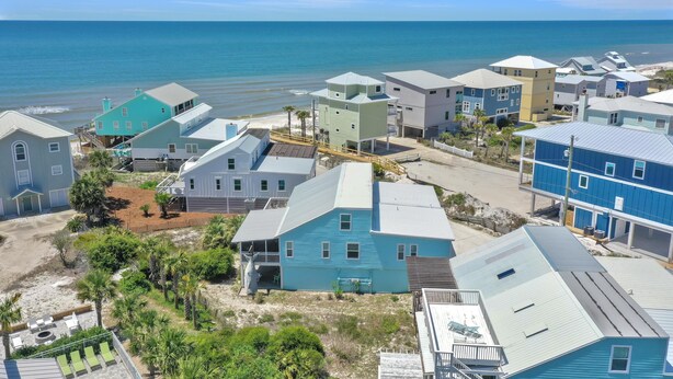 A coastal residential area with houses, a beach, and a clear sky. - Sharkey's (Port St. Joe)