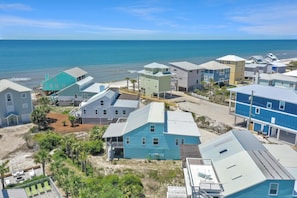 Une zone résidentielle côtière avec des maisons, une plage et un ciel dégagé.