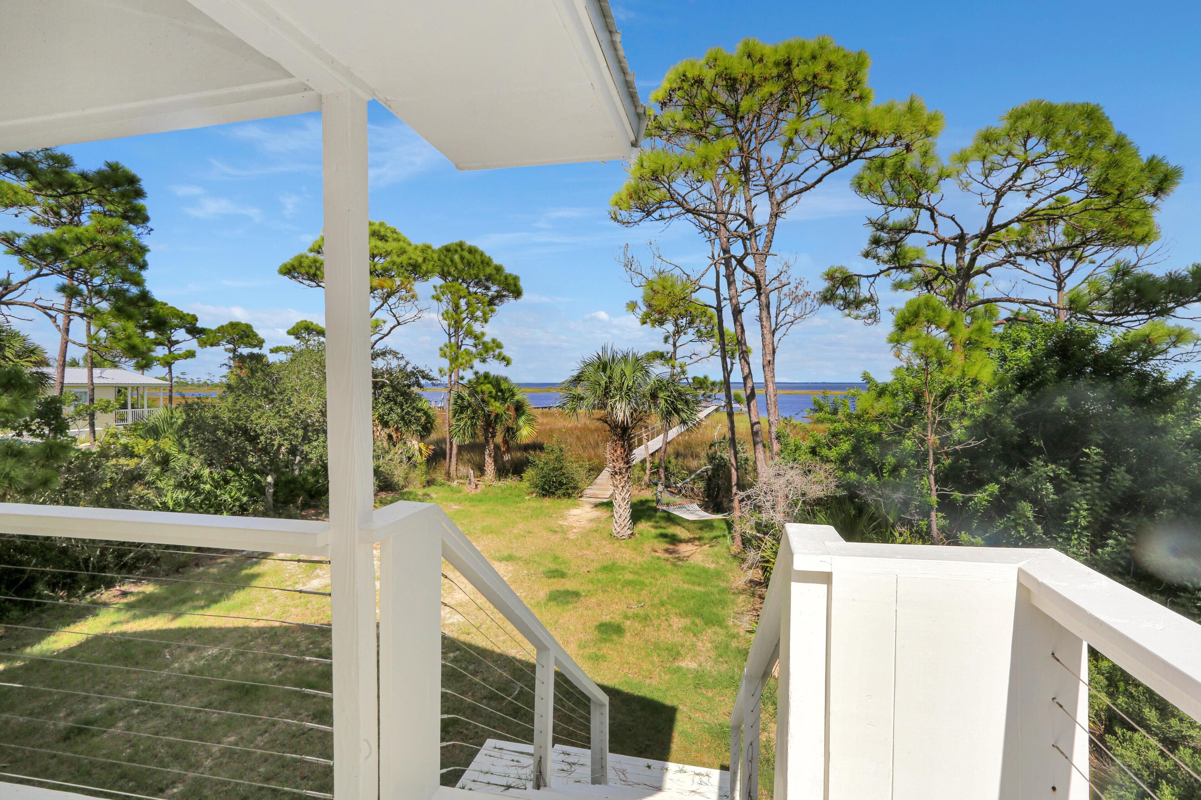 A covered outdoor area with a view of a grassy landscape and trees.