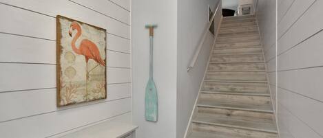 A staircase with wooden steps and a wall-mounted painting of a flamingo.