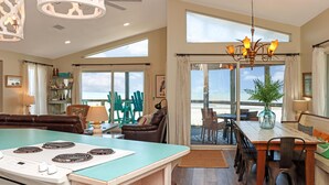 A spacious kitchen with a large island, a dining area with a view, and a cozy seating area with a view of the beach. - WindScape (Port St. Joe)