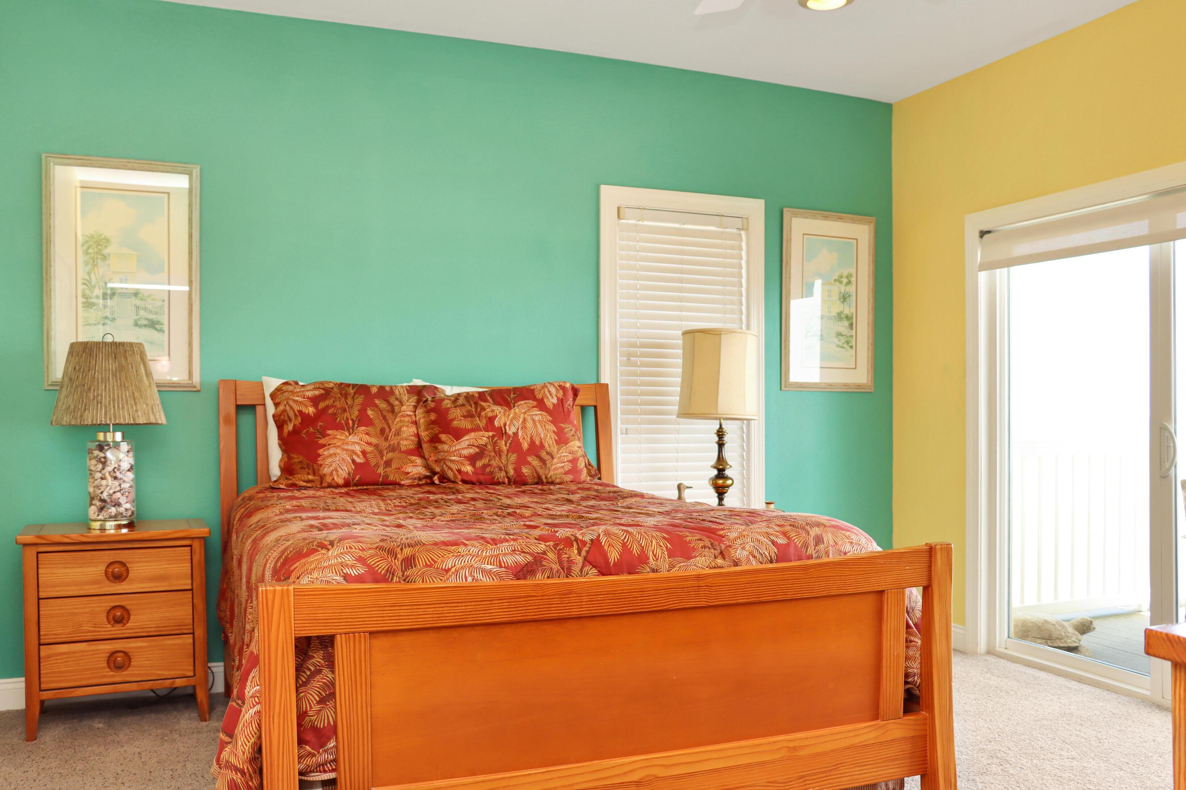 A bedroom with a wooden bed, two bedside tables, a nightstand, and a window with blinds.