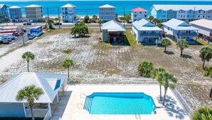 A beachfront property with a swimming pool, multiple buildings, and a view of the ocean. - The Shore House (Port St. Joe)