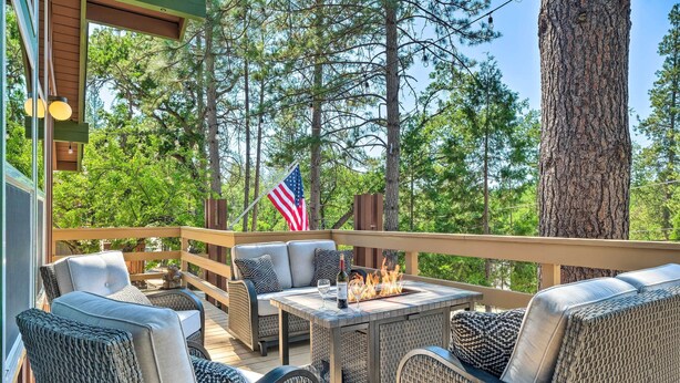 An outdoor deck with wicker furniture, a fire pit, and an American flag. - Cabin < Half-Mi from Pine Mountain Lake Marina! (Groveland)