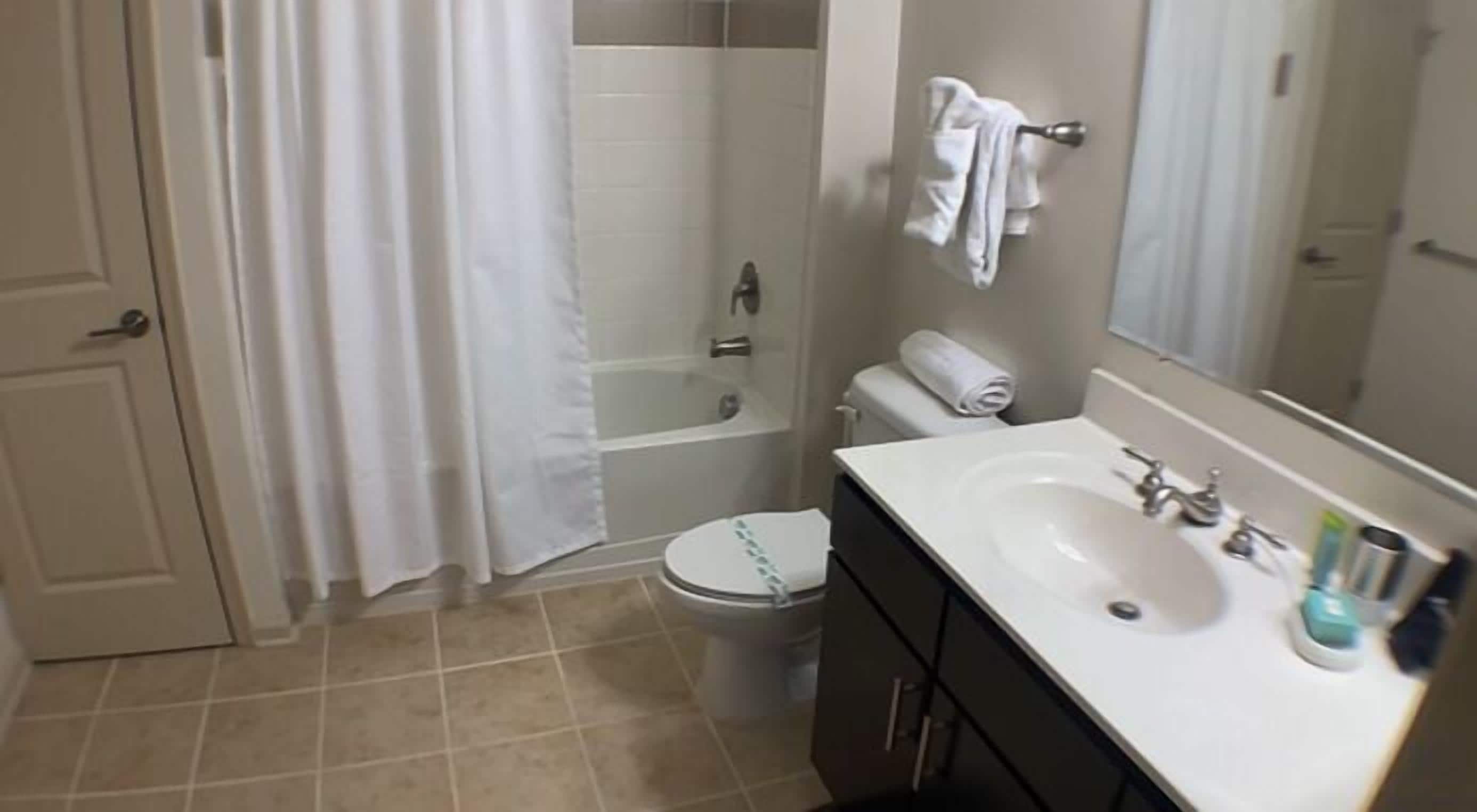 A bathroom with a bathtub, toilet, and sink.