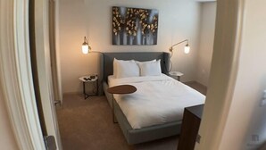 A modern hotel room with a bed, bedside tables, and a painting on the wall. - National at Clarendon (Arlington)