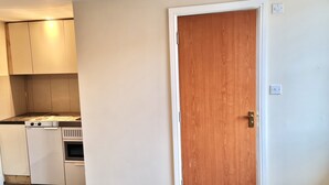 Une cuisine avec des meubles blancs, une cuisinière et un four à micro-ondes.