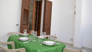 A dining table set with plates, glasses, and cutlery, surrounded by chairs. - Casa Vacanze Mediterranea (Gagliano del Capo)