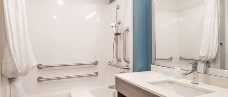 A modern bathroom with a bathtub, shower, and vanity.