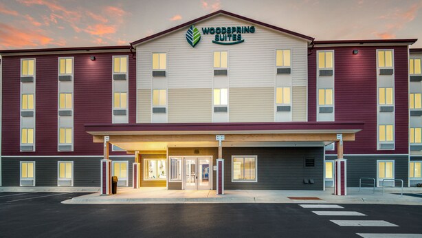 Ein Hotel mit einer schokoladenbraunen und beigen Fassade, einem gut sichtbaren Logo und einem gut beleuchteten Eingang.