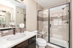 A modern bathroom with a large sink, mirror, and a glass-enclosed shower. - Spectacular Townhome near Breweries and River District! (Fort Collins)