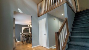 A staircase with wooden railings leading to a landing. - Lake Adjacent Home w/ Hot Tub, Game Room, Boats, Fenced Yard (East Stroudsburg)