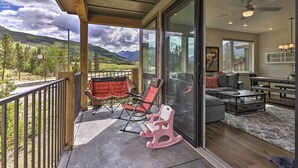 A balcony with a view of mountains, a seating area with a sofa and chairs, and a dining table. - Walk to Lifts: Condo w/ Mtn Views in Keystone! (Keystone)