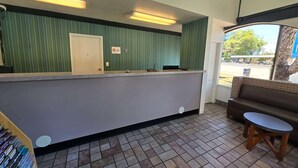 A reception area with a counter, a sofa, and a small table. - Super 8 by Wyndham San Jose Airport (San Jose)