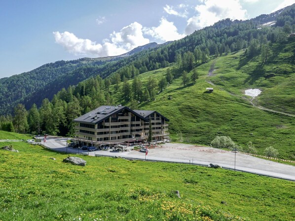 Un hôtel à plusieurs étages doté d'un télésiège, situé dans une région montagneuse.