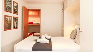 A neatly arranged hotel room with a bed, a bedside lamp, and a wardrobe. - Nice apartment for 4 people with WIFI, TV and balcony (Basse-nendaz)