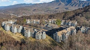 A residential area with modern houses, a parking lot, and a mountainous backdrop. - Mountain Top Adventure Condo (Gatlinburg)