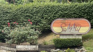 A wooden sign with the name 'GATLINBURG' and 'Ski View Dr.' in front of a lush green backdrop. - Mountain Top Adventure Condo (Gatlinburg)