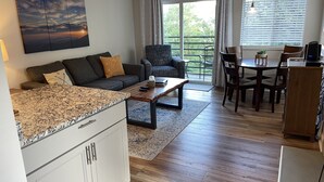 A modern living room with a sofa, coffee table, and dining area. - Mountain Top Adventure Condo (Gatlinburg)