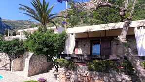 A stone-walled building with a pool, surrounded by greenery and a mountainous backdrop. - Lovely apartment for 2 guests with pool, WIFI, A/C and TV (Castellammare Del Golfo)