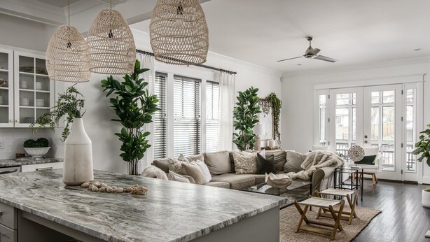 A spacious kitchen with a marble island, a large sofa, and a dining area with wooden chairs. - Salt In The City a Downtown Retreat-Hidden rooftop with Downtown Skyline Views. (Nashville)