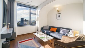 A modern living room with a sofa, coffee table, and a view of the city. - Urban (Mokpo)